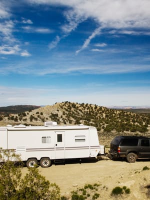 53788-car-pulling-trailer-in-desert-landscape-gra-2026-03-25-05-13-23-utc.